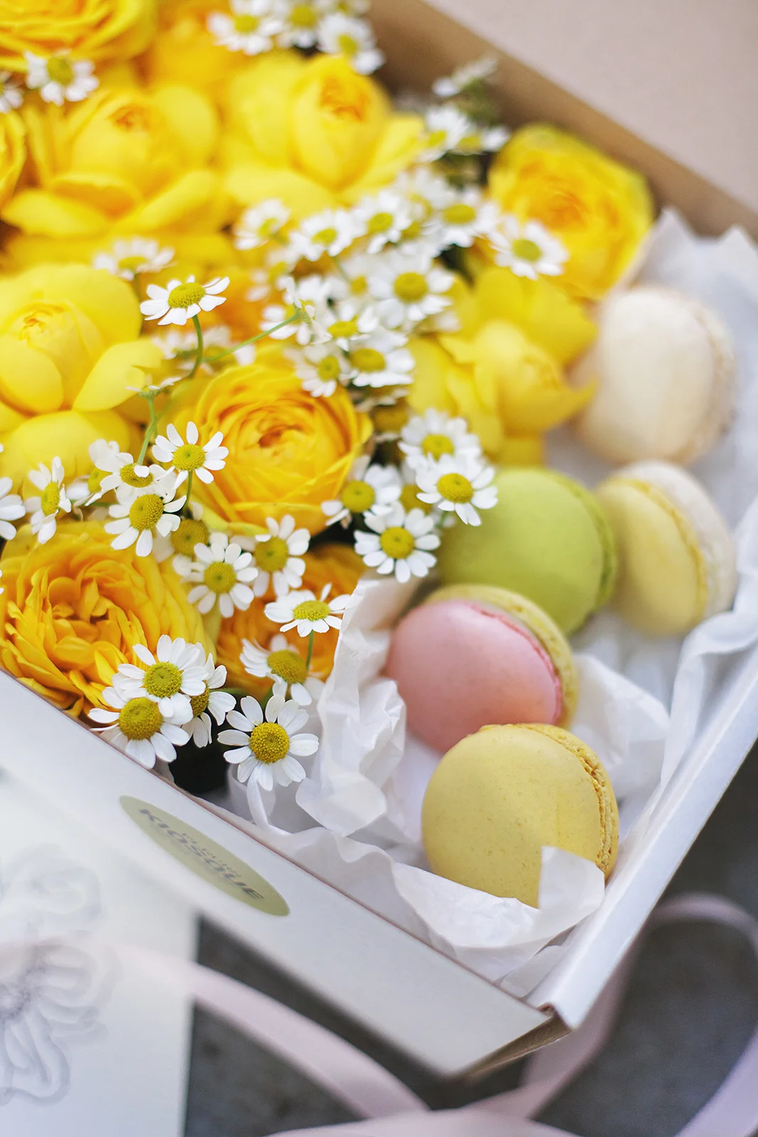 Цветочная композиция из пионовидных кустовых роз и пирожных макаронс